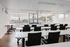 Klassenzimmer der BBS Business-School St. Gallen mit großzügiger Fensterfront und Ausblick auf die Stadt.