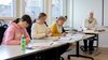 Engagierte Teilnehmerinnen in einem Kurs der BBS Business-School Schule St. Gallen, unter der Aufsicht einer erfahrenen Lehrerin.