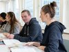 Teilnehmer eines Sprachkurses arbeiten konzentriert in einer interaktiven Lernumgebung der BBS Business-School St. Gallen.
